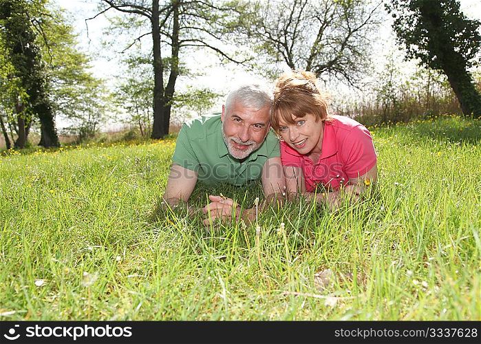 Portrait of senior couple laying in grass