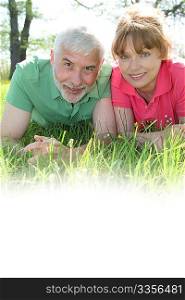 Portrait of senior couple laying in grass