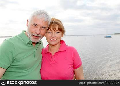 Portrait of senior couple standing by a lake