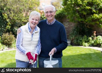 Portrait Of Senior Couple Working In Garden Together