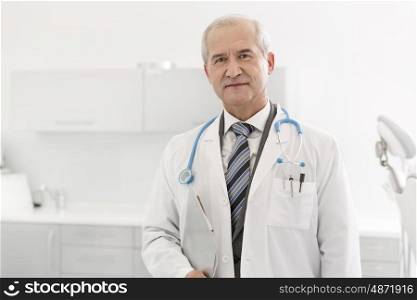 Portrait of senior doctor with clipboard at dental clinic