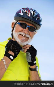 Portrait of Senior man adjusting cycling helmet