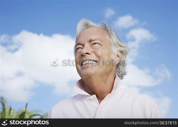 Portrait of senior man against sky, smiling