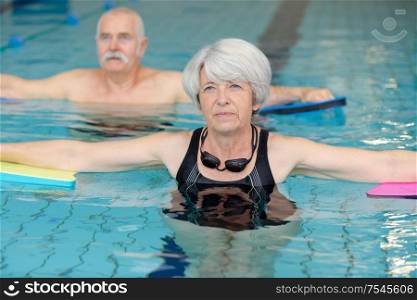 portrait of senior man and woman in swimming pool