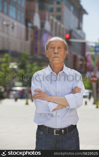 Portrait of senior man, arms crossed, outdoors in Beijing