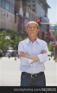 Portrait of senior man, arms crossed, outdoors in Beijing