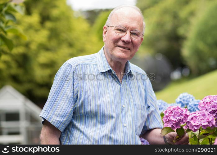 Portrait Of Senior Man Enjoying Garden At Home