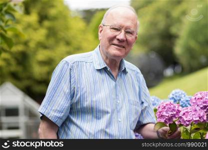 Portrait Of Senior Man Enjoying Garden At Home