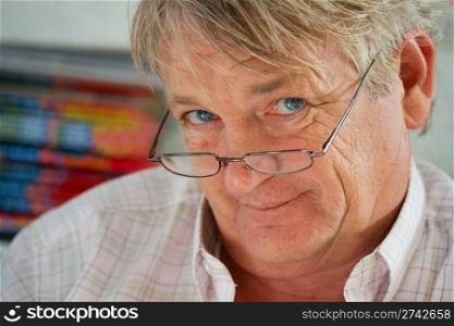 Portrait of senior man in glasses, looking at you, smiling.