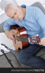portrait of senior man playing acoustic guitar