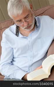 Portrait of senior man reading a book