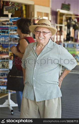 Portrait of senior man standing by souvenir stand