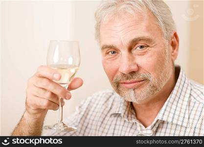 Portrait of senior mature man with glass of white wine