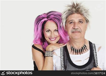Portrait of senior punk couple over gray background