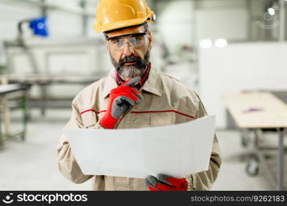 Portrait of senior supervisor looking at projest in the factory