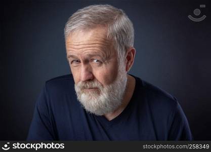 Portrait of senior with gray beard and a deep look
