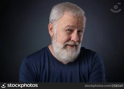 Portrait of senior with gray beard and a suspicious look