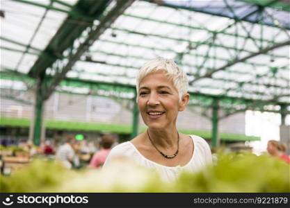 Portrait of senior woman buying fresh organic vegetable on market