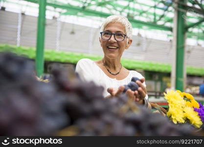 Portrait of senior woman buying fruit on market