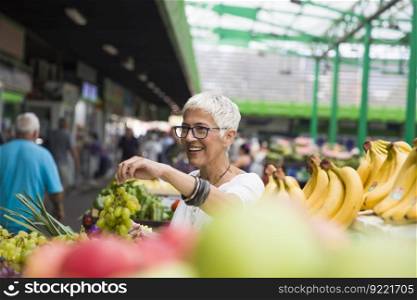 Portrait of senior woman buying fruits on market