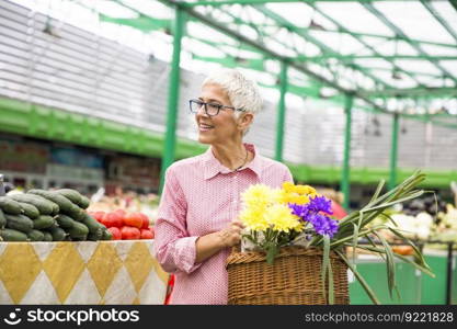 Portrait of senior woman buying on market