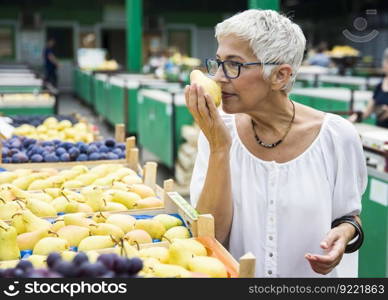 Portrait of senior woman buying on market