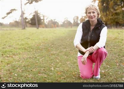 Portrait Of Senior Woman Crouching In The Park