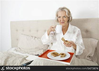 Portrait of senior woman having breakfast in bed
