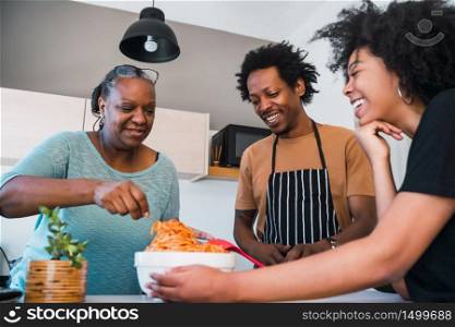 Portrait of senior woman helping daughter and son in law to cook at home. Family and lifestyle concept.