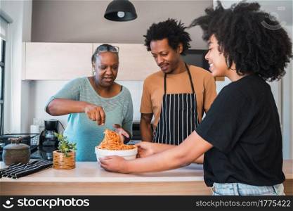 Portrait of senior woman helping daughter and son in law to cook at home. Family and lifestyle concept.