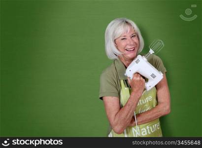 Portrait of senior woman holding mixer