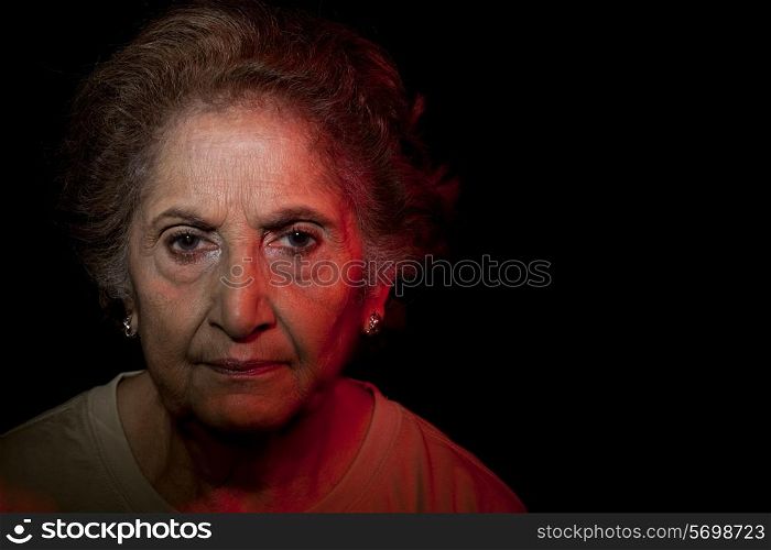 Portrait of senior woman over black background