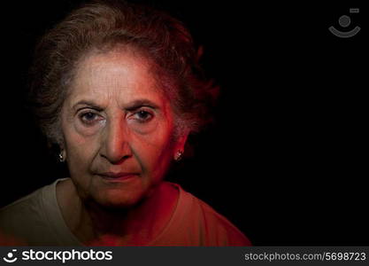 Portrait of senior woman over black background