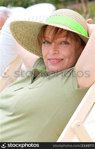 Portrait of senior woman relaxing in deck chair