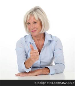 Portrait of senior woman showing thumb up