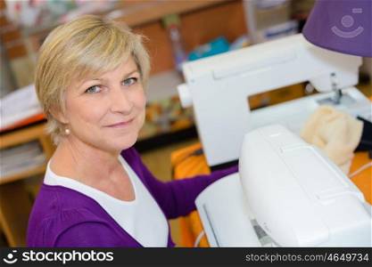 Portrait of senior woman using sewing machine