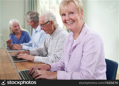 Portrait Of Senior Woman With Tutor In Computer Class