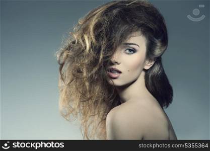 portrait of sensual woman posing with naked shoulders and bushy wild hair-style