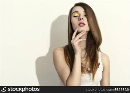 portrait of sensual woman with fashion spring style, long smooth hair and colorful necklace posing with relaxed expression