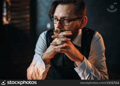Portrait of serious brooding, bearded man in glasses. Writer, journalist, literature author, blogger or poet concept. Serious brooding bearded man in glasses