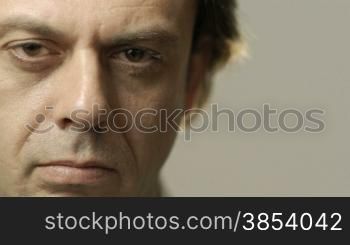 Portrait of serious caucasian adult man staring at camera. Cropped view, gray background, copy space