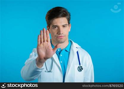 Portrait of serious doctor in professional medical white coat showing rejecting gesture by stop palm sign. Doc man isolated on blue background. High quality photo. Portrait of serious doctor in professional medical white coat showing rejecting gesture by stop palm sign. Doc man isolated on blue background.