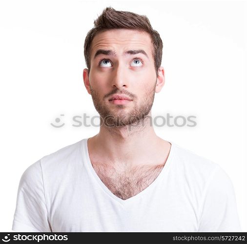 Portrait of serious handsome young man looking up - isolated on white.