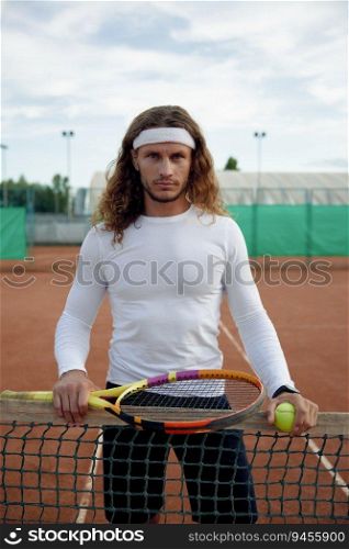 Portrait of serious male tennis player feeling strong and motivation. Young athletic sportsman looking determined and confident. Portrait of serious male tennis player feeling strong and motivation