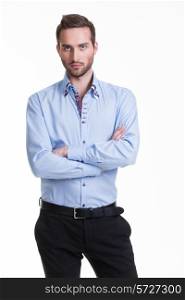 Portrait of serious man in blue shirt and black pants with crossed arms - isolated on white.&#xA;