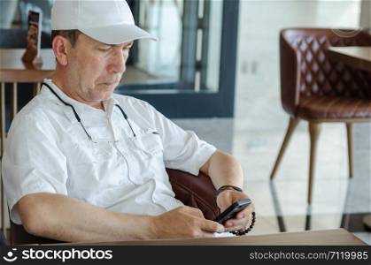 Portrait of serious man using smartphone at the cafe