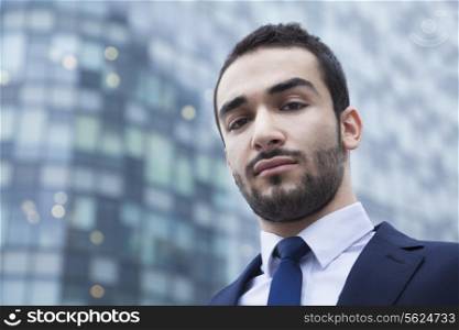 Portrait of serious young businessman, outdoors, business district
