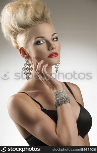 portrait of sexy blonde girl with black bra, modern creative hair-style and glossy jewelleries