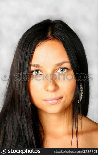 portrait of sexy brunette with good haircut on the grey background