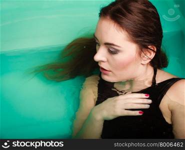 Portrait of sexy seductive woman in water.. Portrait of sexy seductive woman wearing black dress in swimming pool water. Young attractive alluring girl floating. Top view.